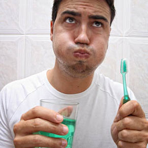 Guy using mouthwash